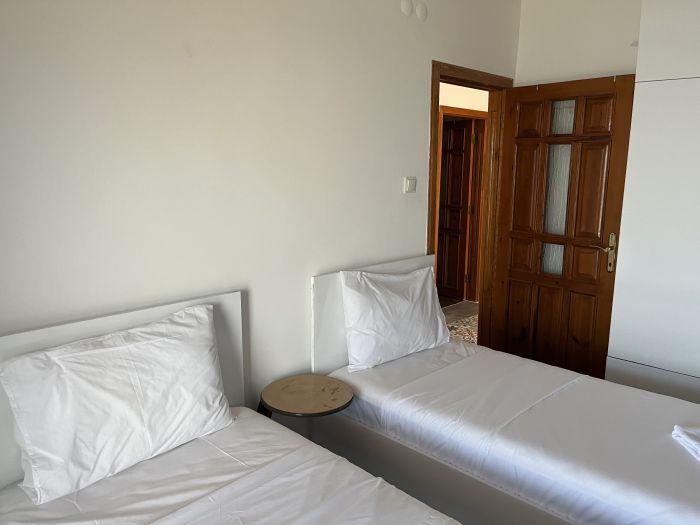 The second and third bedrooms include two single beds.
