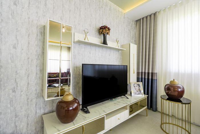 You'll be greeted by a cozy living room adorned with modern touches and a comfortable sofa, perfect for unwinding while enjoying your favorite TV shows.