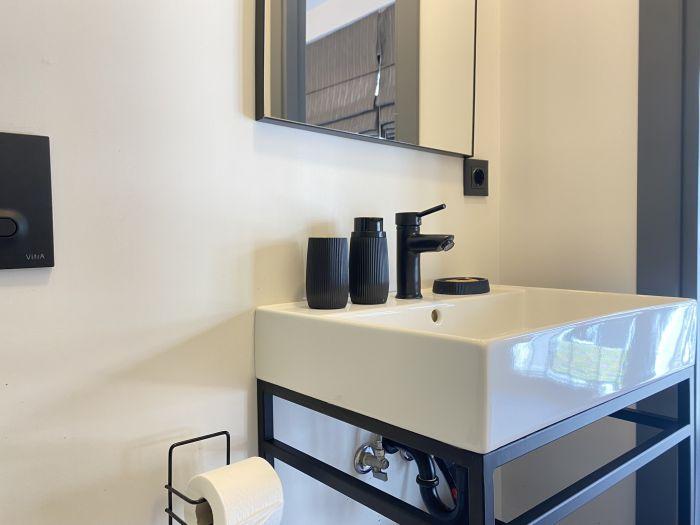 Isn't the bathroom designed very stylishly? The luxurious black fixtures add a unique touch to the bathroom.