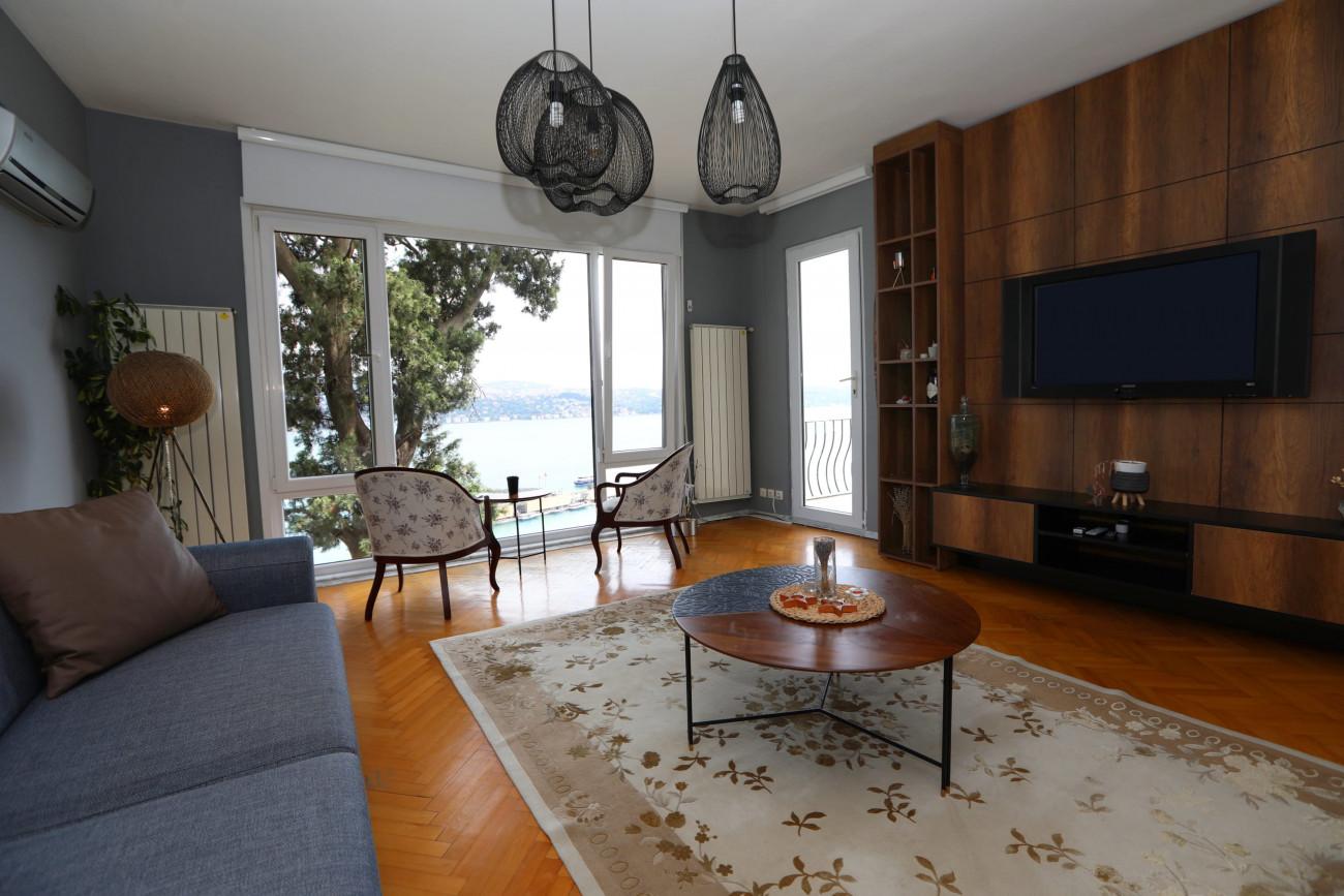 The living room has an elegant design with darker tones.