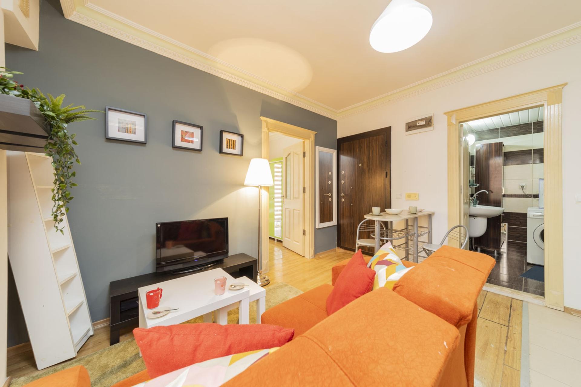 This living room offers you total comfort with its orange and comfy sofa.