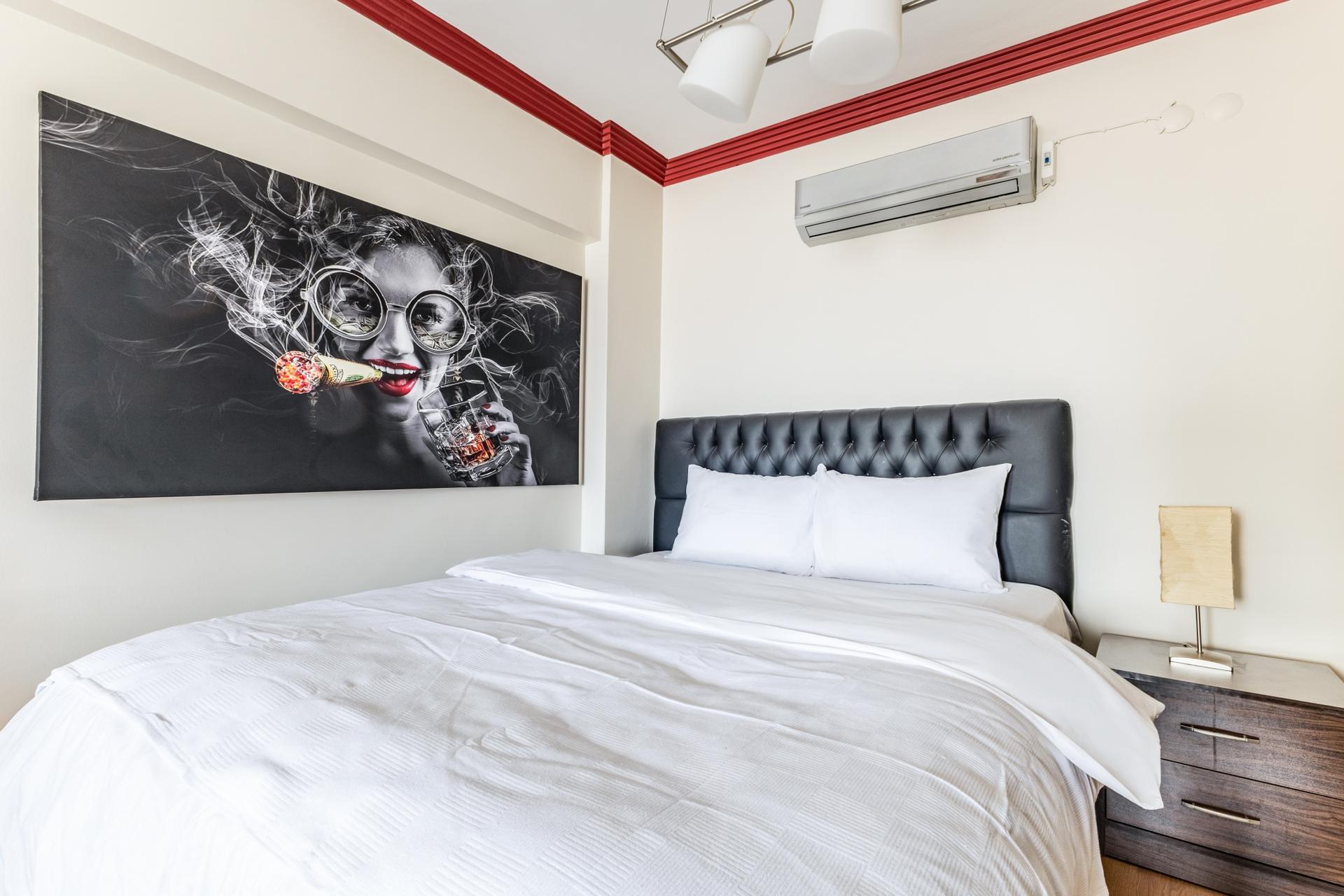 The bedroom is immaculate, with a freshly made bed and pristine surfaces that create a welcoming and relaxing atmosphere.