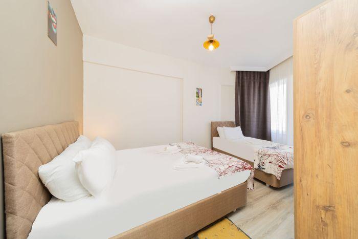 Our main bedroom features a comfy double bed, a single bed, and two nightstands with lights.