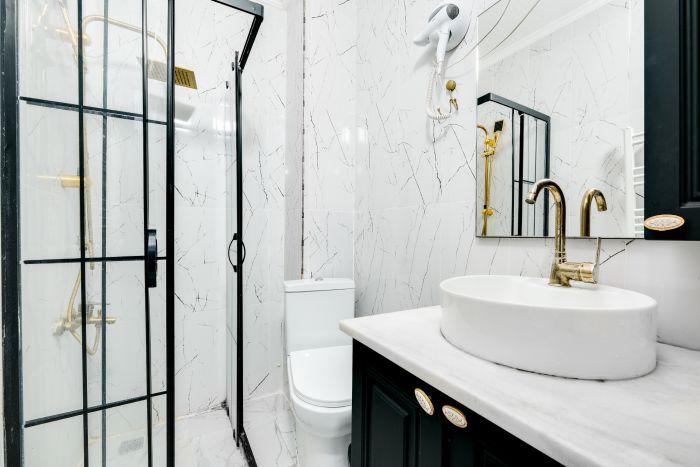 This studio bathroom is a masterclass in space-saving design, blending style with practicality.