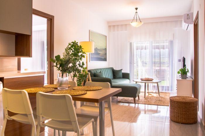 The living room features a dining table for four people.