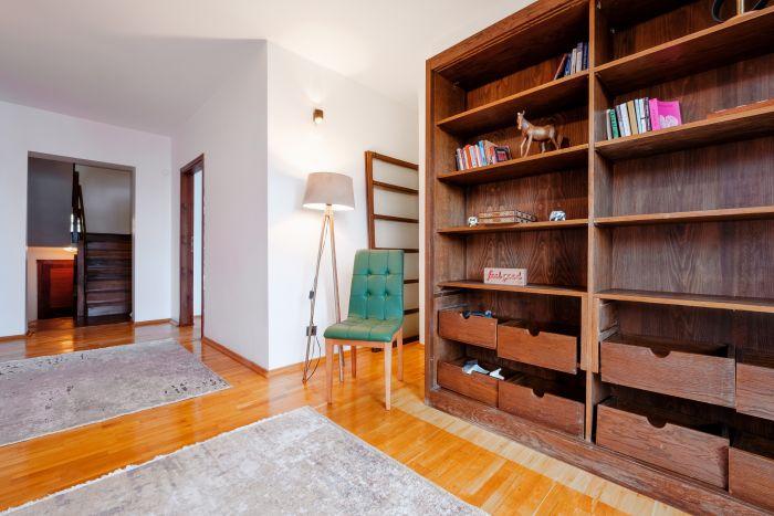 A cozy living room with a large bookshelf that invites you to unwind with a good book.