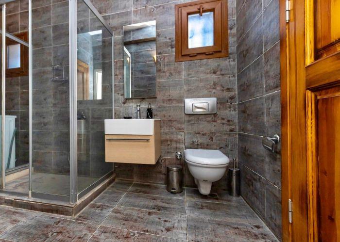 Our refreshing bathroom has bright tiles, useful toiletries, and enough storage space to enhance your experience.