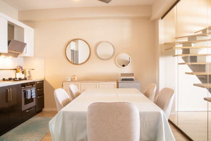 The kitchen also includes a large dining table for up to 6 people and decorative mirrors.