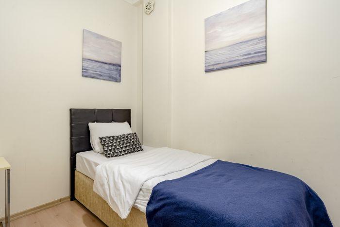 The second bedroom features a single bed and some paintings to uplift your mood.