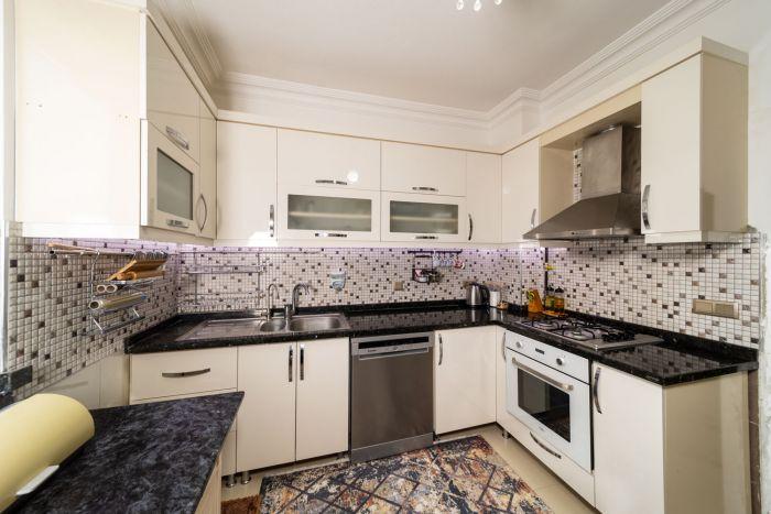 The kitchen is well equipped white modern white goods and appliances.