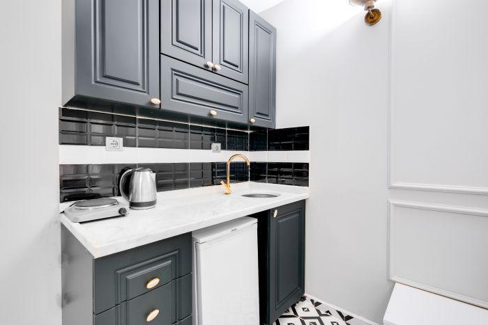 Efficiency meets style in this small yet chic studio kitchen, where every appliance has its perfect spot.