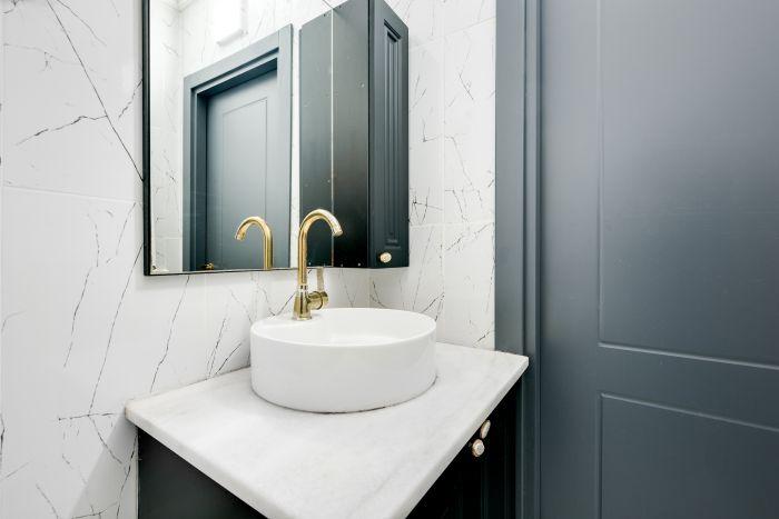 Modern minimalism shines in this studio bathroom, featuring sleek fixtures and a clean aesthetic.