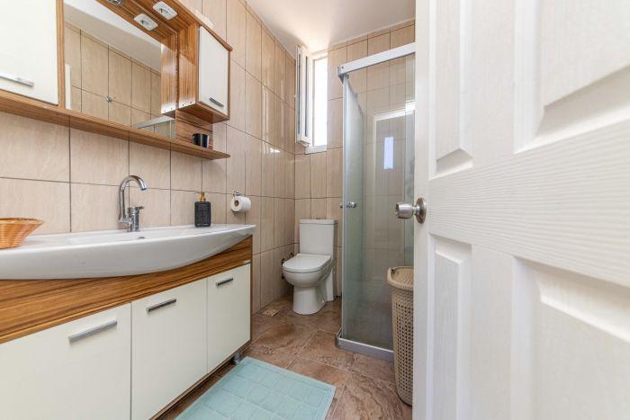 You could have a stylish bathroom with wooden tones and a shower cabin.