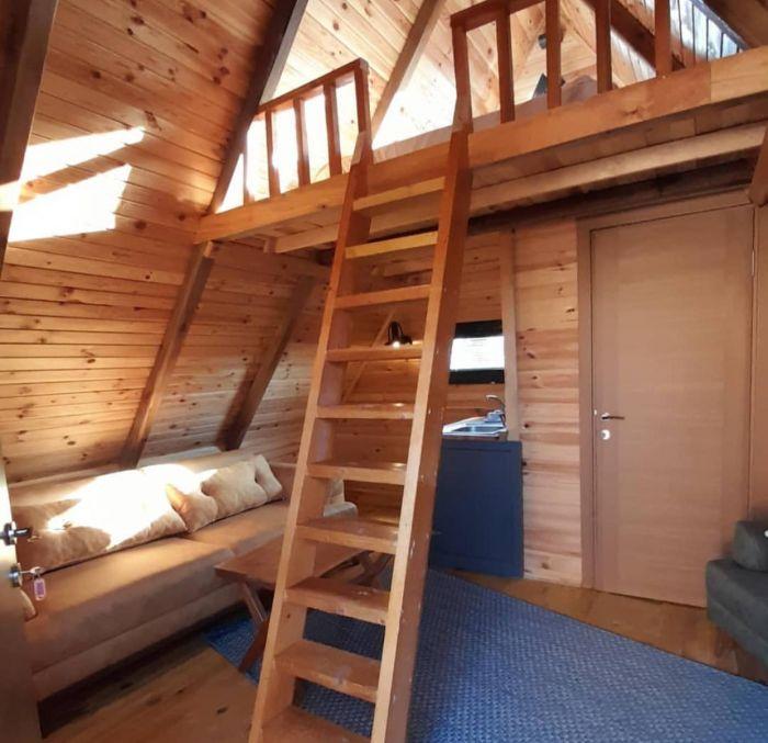 The interior has a living area downstairs and a lofted bedroom.