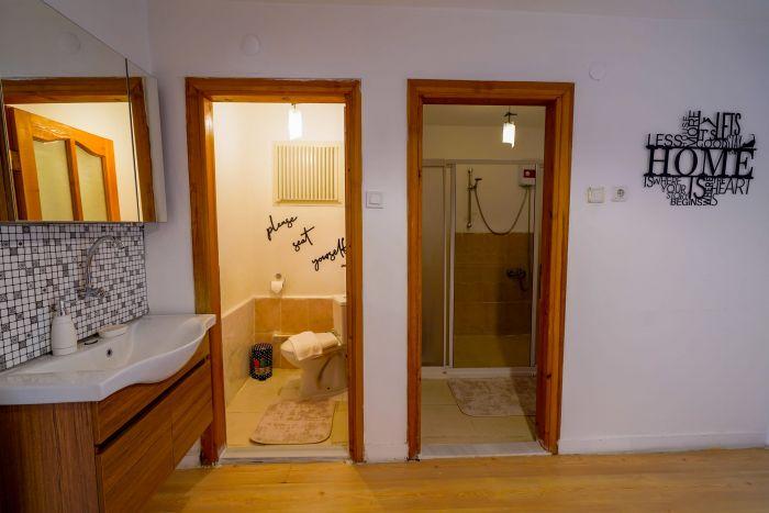 The bathroom is divided into two parts and the lavatory is located in the hallway.