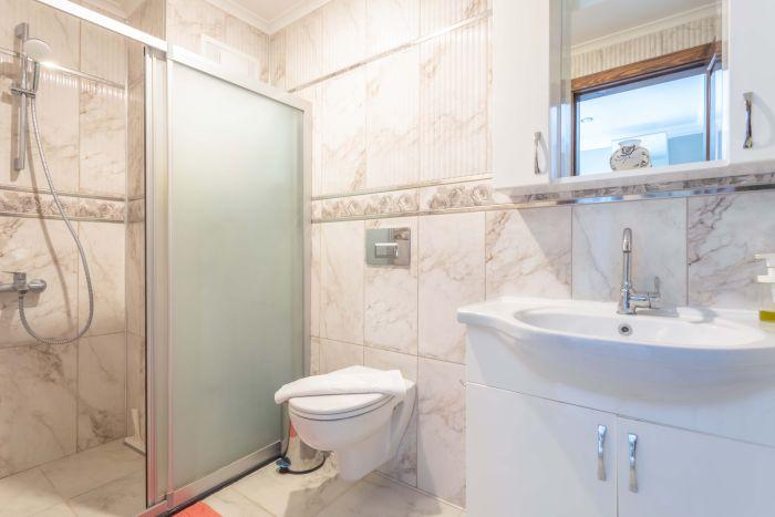 The bathroom features a large shower cabin, and all necessary hygiene products will be provided upon your arrival.