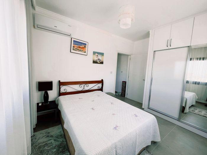 A sleeping sanctuary dominated by white with its AC, large wardrobe and comfortable double bed.