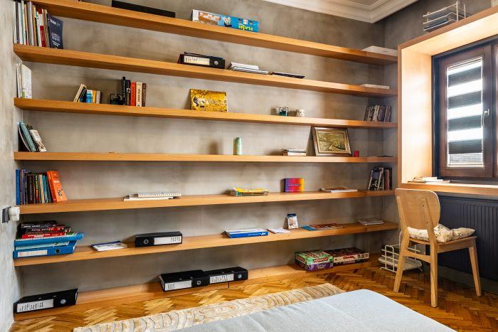 Here, there's a comfortable bed and a large bookshelf.